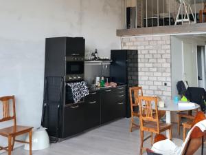 eine Küche mit schwarzen Geräten sowie einem Tisch und Stühlen in der Unterkunft Köima Loft in Kõima