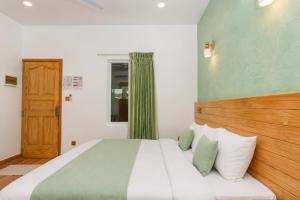 a bedroom with a large bed with a wooden headboard at Turtle Maldives - Your Gateway to the Beach & Marine Adventures Await! in Omadhoo