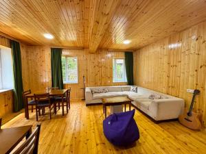 a living room with a couch and a table at Svaneti Heaven in Lentekhi