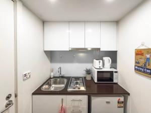 a small kitchen with a sink and a microwave at Puddings Home Compact Apartment State Library in Melbourne