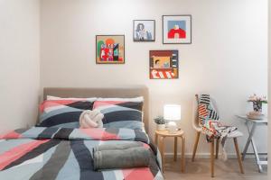 a bedroom with a bed and some pictures on the wall at Puddings Home Compact Apartment State Library in Melbourne