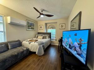 a living room with a bed and a flat screen tv at Ruskin FL 2 bdrm 1 bath suite Host & Cat share common areas in Ruskin