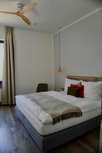 a bedroom with a bed and a ceiling fan at Boutique-Hotel "Stilvoll" in Andernach +16 photos