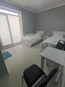 a room with two beds and a table and chairs at VSt GRAND HOTEL in Ninotsminda