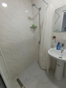 a white bathroom with a shower and a sink at VSt GRAND HOTEL in Ninotsminda