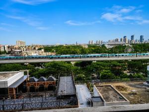 a train is crossing a bridge over a city at Velvet Nook in Greater Noida