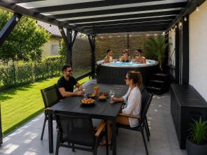 a group of people sitting at a table in front of a hot tub at Całoroczny Domek Chill in Sława