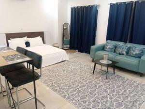 a bedroom with a bed and a couch and a table at la maison PAIX in Île de Petit-Bassam