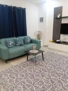 a living room with a green couch and a table at la maison PAIX in Île de Petit-Bassam