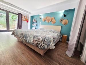 a bedroom with a bed and a blue wall at Le Chalet de Pyrène et Hercule in Arignac