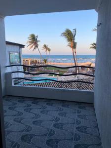 a view of the beach from a balcony with palm trees at Hotel Panorama do Mar - Praia do Futuro in Fortaleza