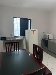 a kitchen with a table and a refrigerator at Hotel Panorama do Mar - Praia do Futuro in Fortaleza +4 photos