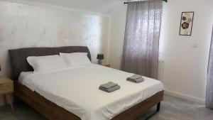 a bedroom with a bed with two towels on it at Casa A&A Stefan Livada in Livada