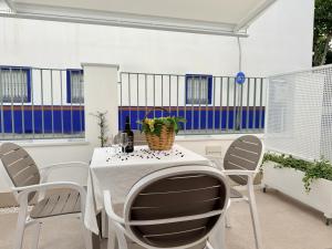 a dining room with a white table and chairs at Villa Julia Apartamentos in Chipiona +84 photos