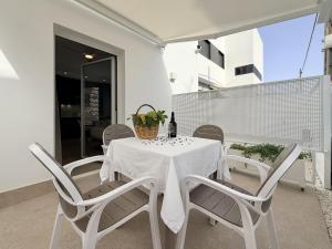 a white table and chairs on a balcony at Villa Julia Apartamentos in Chipiona