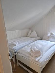two beds in a room with white sheets and pillows at Charming House In Herrliberg in Herrliberg