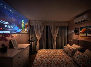 a bedroom with a bed and a large screen at Casa Elegante V3 Moderna 2 Suítes, Jardim e Garagem Privados in Olhão +14 photos