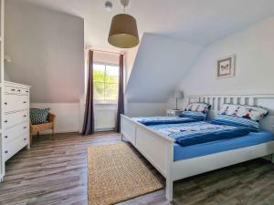 a bedroom with a bed with blue sheets and a window at Liekedeeler in Greetsiel