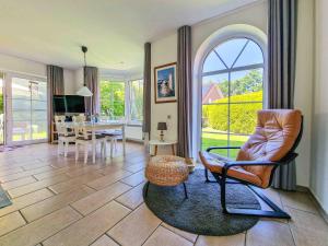 a living room with a chair and a dining room at Liekedeeler in Greetsiel