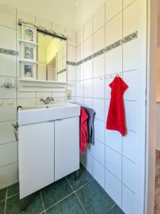a white bathroom with a sink and a mirror at Liekedeeler in Greetsiel +25 photos