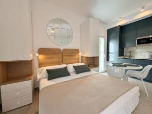 a bedroom with a large bed and a kitchen at Villa Julia Apartamentos in Chipiona