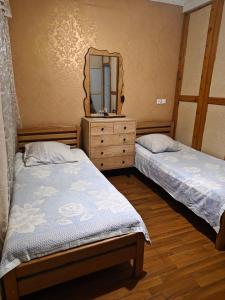 two beds in a room with a mirror and a dresser at 9 Plus - Orbeli in Orbeli