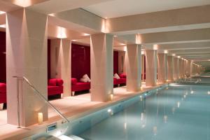 a swimming pool in a hotel with red chairs at La Réserve Paris Hotel & Spa in Paris