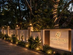 a sign for a villa with lights on a fence at The Silvan Villa Resort in Bangārapet