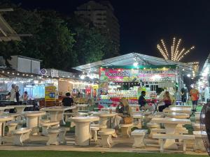 a group of tables and benches in a market at night at New Abani in Jomtien Beach