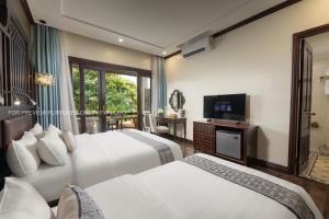 a hotel room with two beds and a television at La palm Luang prabang in Luang Prabang +70 photos