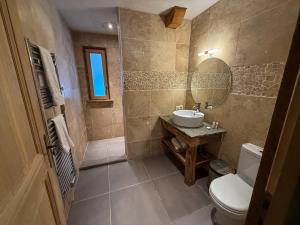 a bathroom with a sink and a toilet and a mirror at Black Diamond Sainte Foy Chalets in Sainte-Foy-Tarentaise +140 photos