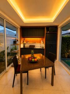 a kitchen with a table with a bowl of fruit on it at Aufwachen im Paradies Private Poolvilla 50 m vom Strand in Nathon Bay
