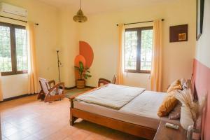 a bedroom with a bed and two windows at Roemah Nelayan in Montongbuwoh
