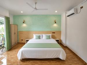 a bedroom with a large bed and a green wall at Turtle Maldives - Your Gateway to the Beach & Marine Adventures Await! in Omadhoo +94 photos
