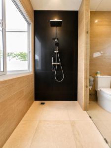 a bathroom with a shower and a black wall at Aufwachen im Paradies Private Poolvilla 50 m vom Strand in Nathon Bay