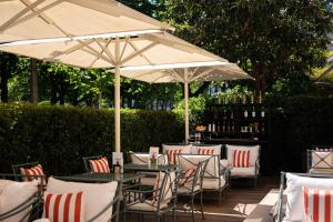 an outdoor patio with tables and chairs with umbrellas at La Réserve Paris Hotel & Spa in Paris