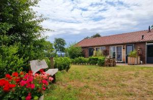 a house with a bench and flowers in the yard at Landelijk overnachten bij Vechtdals Mooiste in Giethmen