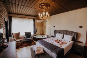 a bedroom with a large bed and a chandelier at Konak Stone House in Ürgüp
