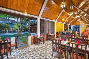 a restaurant with wooden ceilings and tables and chairs at La palm Luang prabang in Luang Prabang