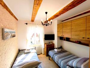 a bedroom with two beds and a window at Holiday House - OLD QUEEN in Šmrika