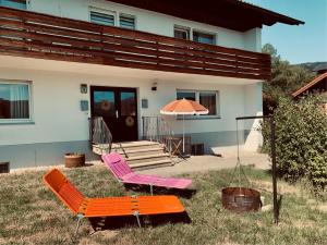 a house with two chairs and an umbrella in the yard at Ferienwohnung Do Blym in Lohberg