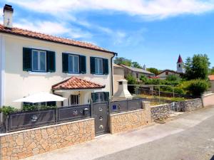 a house with a stone wall and an umbrella at Holiday House - OLD QUEEN in Šmrika
