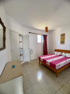 a bedroom with a bed and a table in it at Spacious villa for holidays in Kerkouene +11 photos