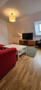 a living room with a couch and a table and a tv at Stora Beddinge - Moon apartment in Klagstorp