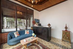 a living room with a blue couch and a table at La palm Luang prabang in Luang Prabang