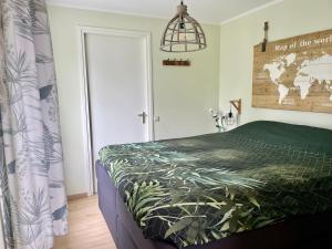 a bedroom with a bed with a green comforter at Welcome by Bianca in Jisp