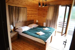 a bedroom with a bed with two towels on it at Cottage Mildiani in Mestia