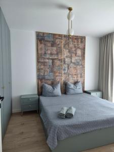 a bedroom with a bed with a brick wall at Apartament Nagiulia in Oradea