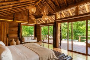 a bedroom with a large bed in a room with windows at Hotel Boutique Maitta en Doradal Antioquia in Doradal
