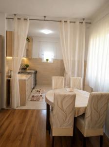 a dining room with a table and chairs and a kitchen at Bgd apartman in Kavač